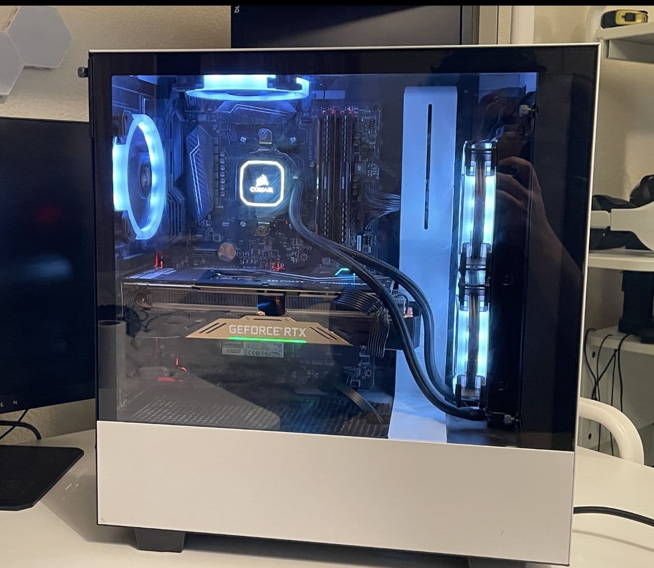 A custom desktop PC with lit cooling and a graphics card, running on the bench