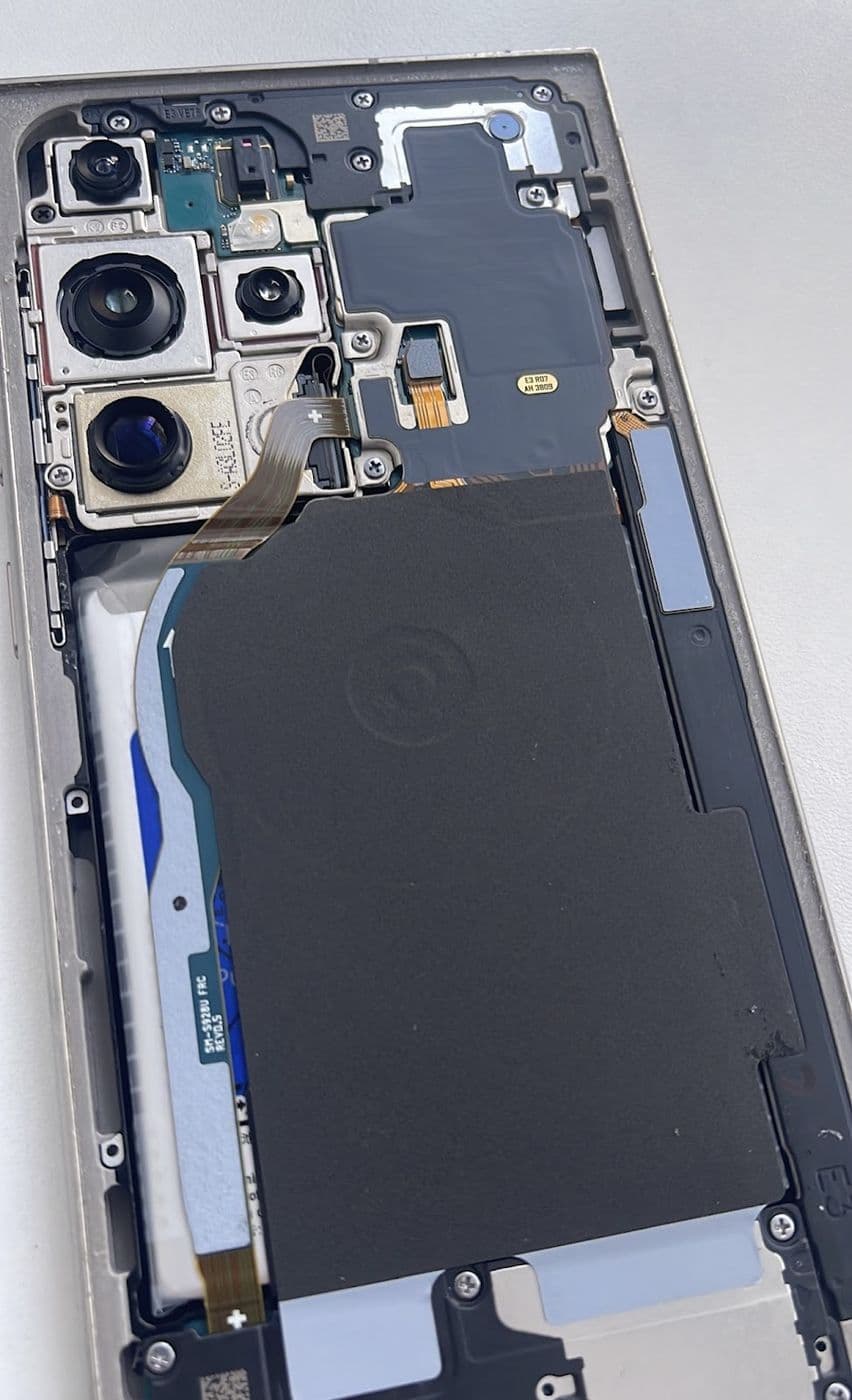 A phone with the back removed, showing the camera module and battery